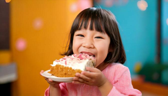 ケーキを口いっぱいに頬張る子供